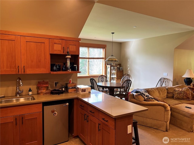 kitchen featuring dishwasher, a kitchen breakfast bar, a peninsula, light countertops, and a sink