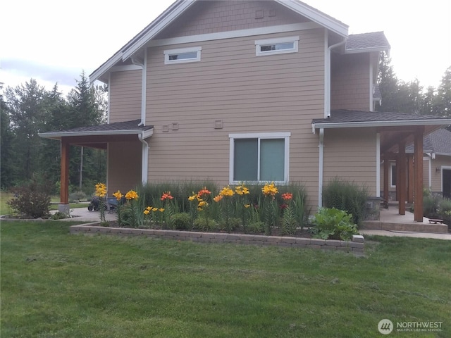 view of side of property with a patio area and a lawn