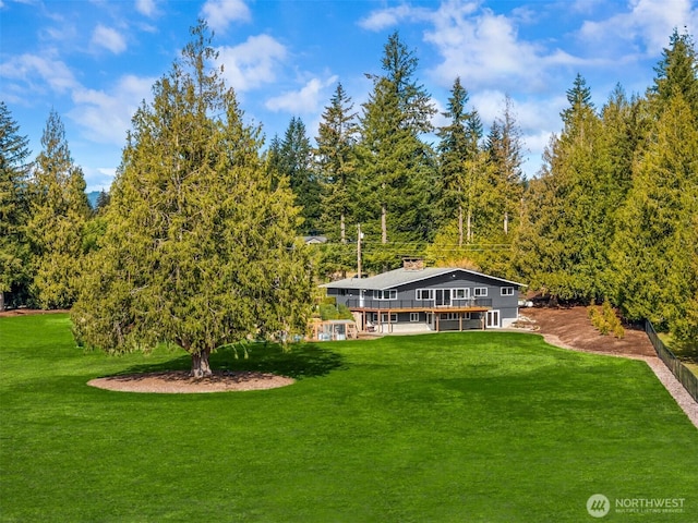 rear view of property with a lawn and a deck