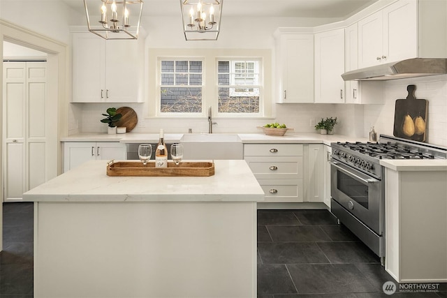 kitchen featuring under cabinet range hood, white cabinetry, stainless steel stove, and a sink