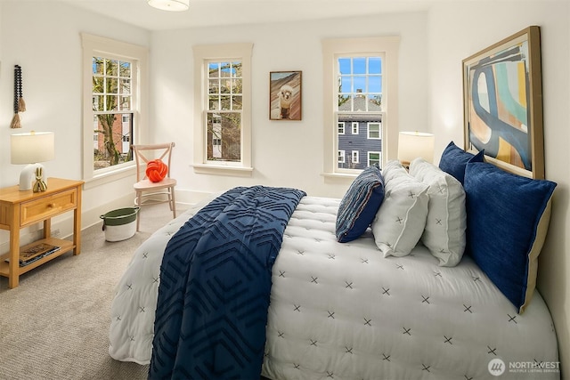 carpeted bedroom with multiple windows and baseboards