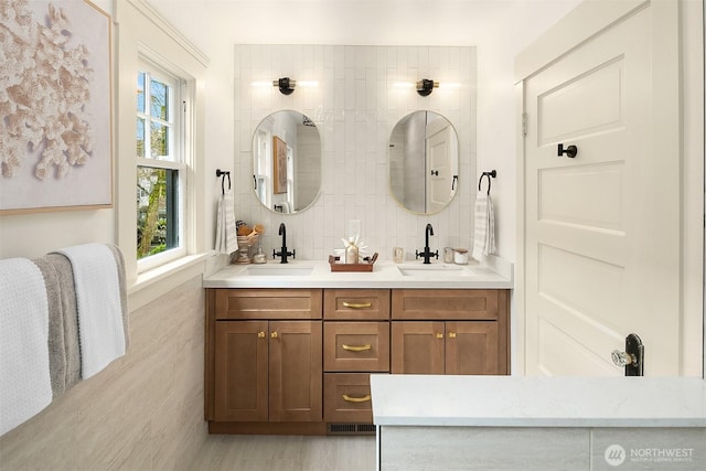 full bathroom with double vanity, visible vents, tile walls, and a sink