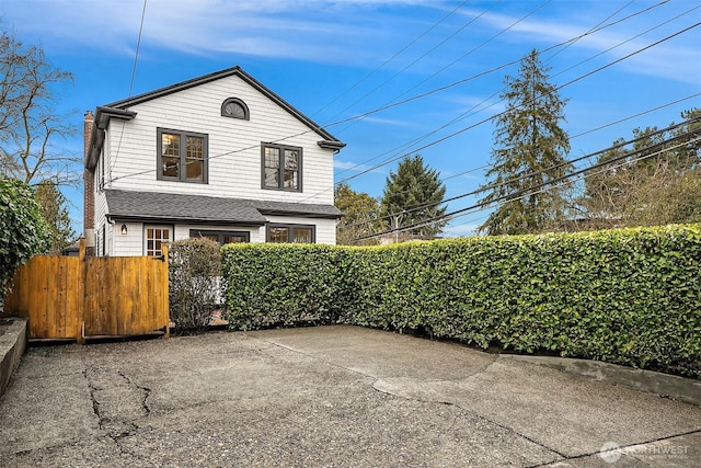 exterior space featuring fence private yard, roof with shingles, and a gate