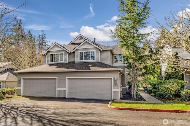 view of front of property featuring a garage, roof with shingles, and driveway