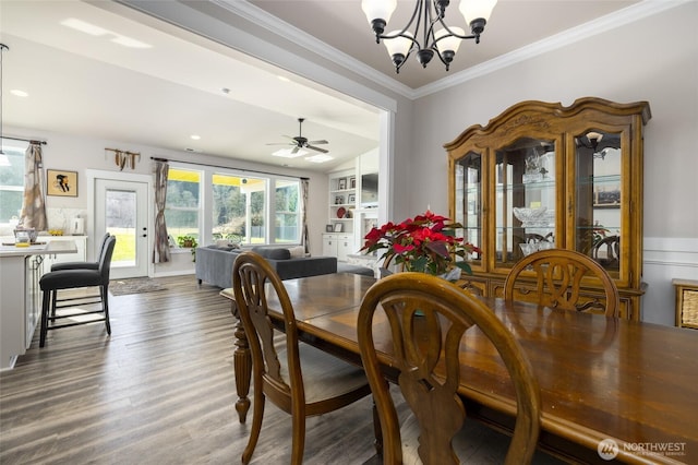 dining space with wood finished floors, ceiling fan with notable chandelier, crown molding, built in shelves, and recessed lighting