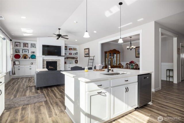 kitchen with dishwasher, dark wood-style floors, a lit fireplace, vaulted ceiling, and a sink