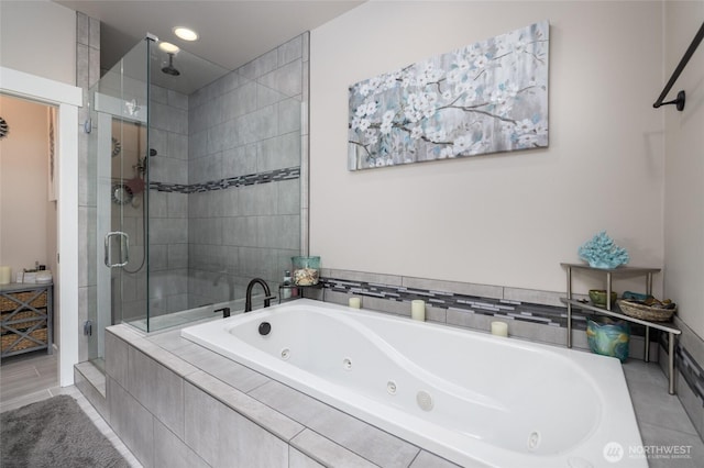 bathroom featuring a stall shower, a jetted tub, and recessed lighting