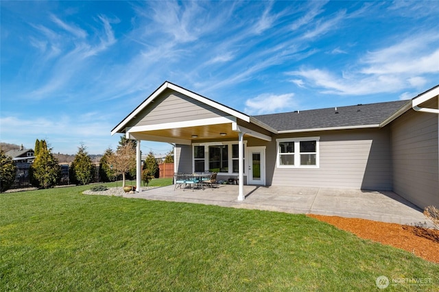 rear view of property with a yard, fence, and a patio