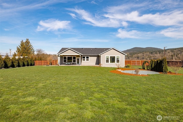 back of property with a yard, a patio area, and a fenced backyard