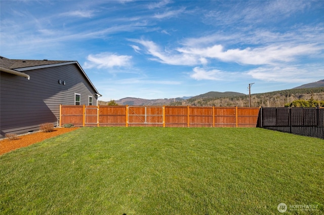 view of yard with a fenced backyard and a mountain view