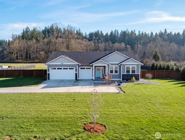 view of front of home with a garage, board and batten siding, a front yard, and fence