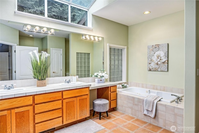 bathroom featuring tile patterned flooring, double vanity, a sink, and a bath