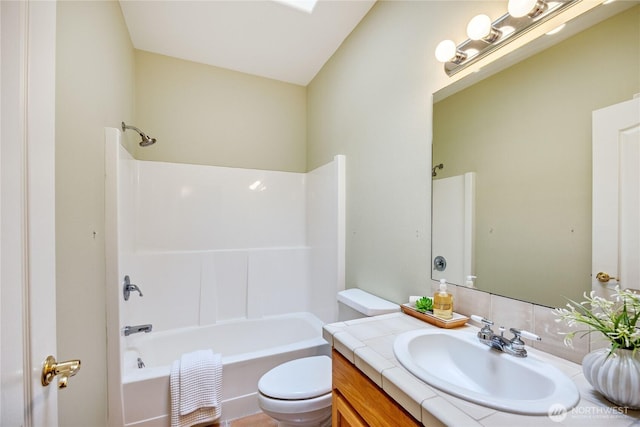 bathroom with bathtub / shower combination, vanity, and toilet