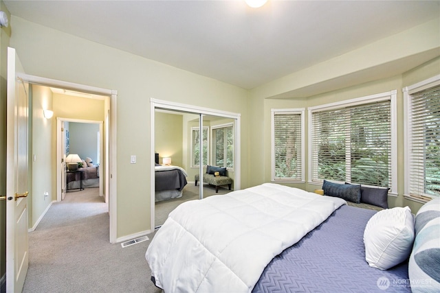 bedroom featuring a closet, carpet flooring, visible vents, and baseboards