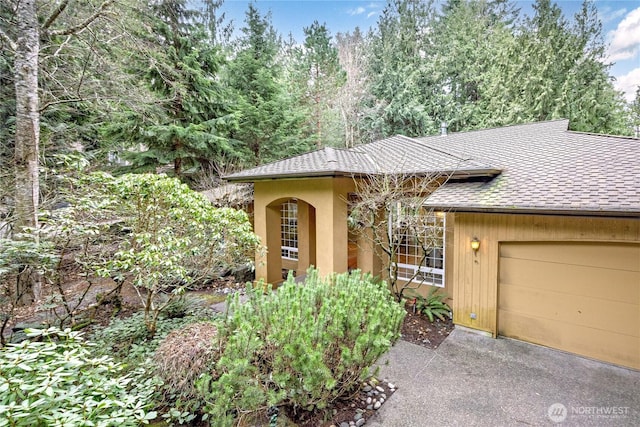 view of front of property with a garage and a shingled roof