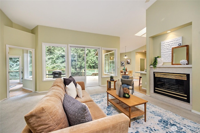 living area with light carpet, vaulted ceiling, baseboards, and a premium fireplace