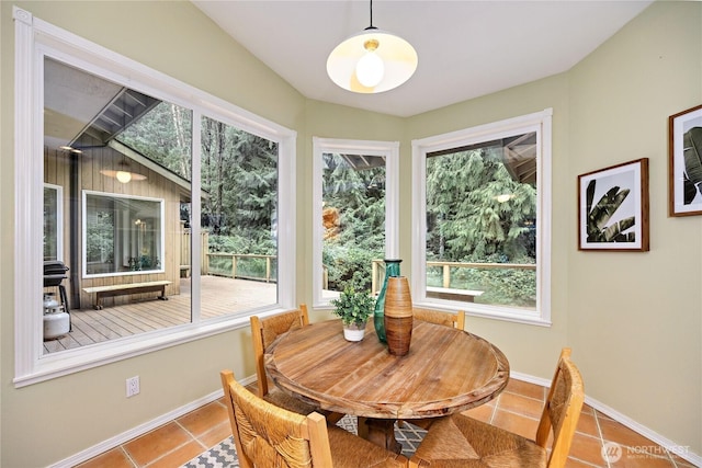 tiled dining room with a healthy amount of sunlight and baseboards