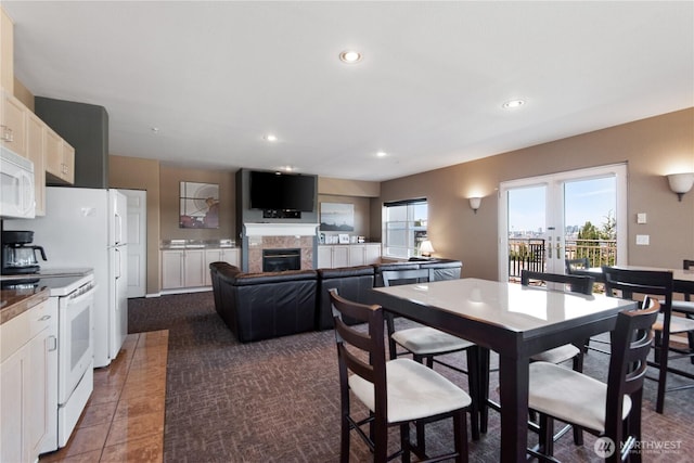 dining space with a tiled fireplace and recessed lighting