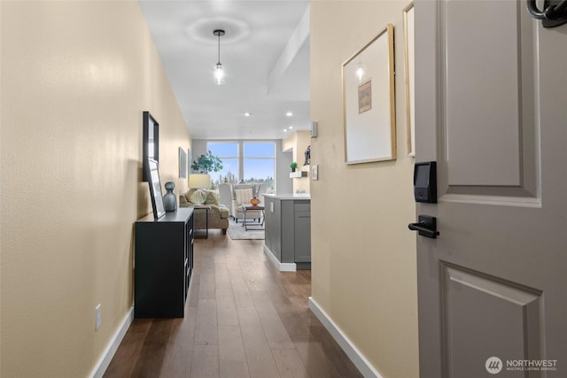 hallway with baseboards, wood finished floors, and recessed lighting