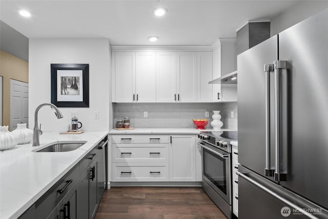 kitchen with light stone counters, dark wood-style flooring, backsplash, appliances with stainless steel finishes, and a sink