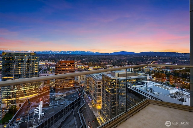 balcony at dusk with a mountain view and a city view