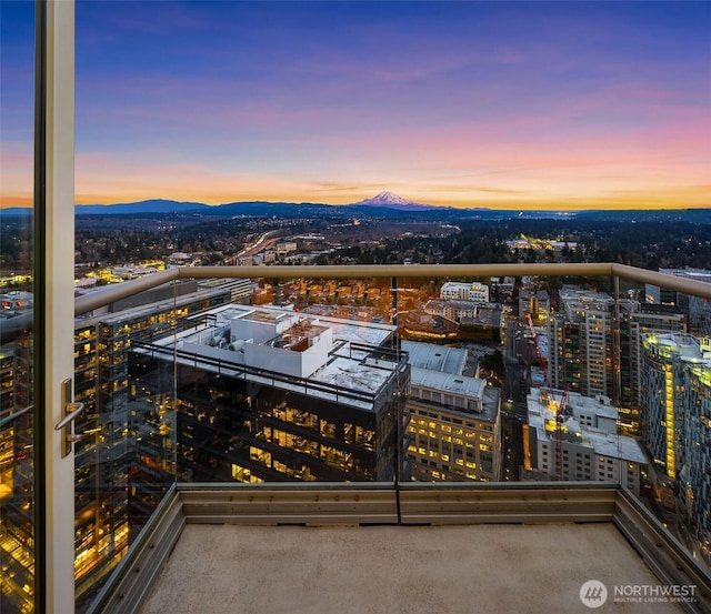 balcony at dusk with a view of city and a mountain view