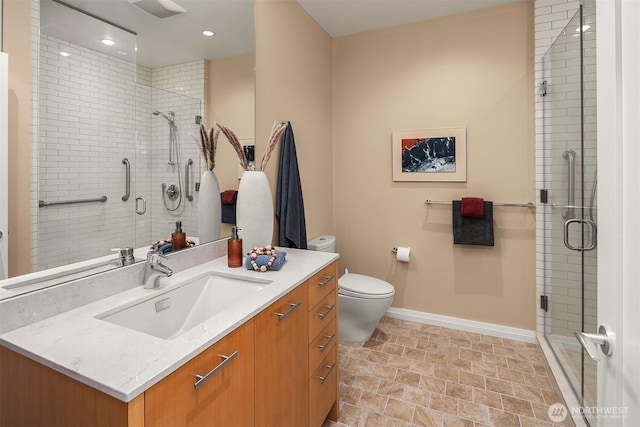 full bathroom featuring toilet, a shower stall, baseboards, and vanity