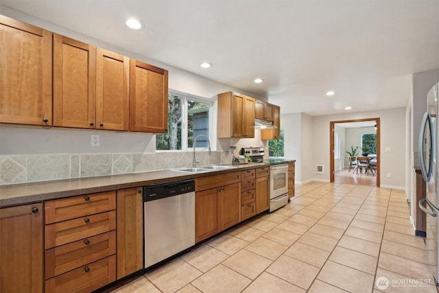 kitchen with light tile patterned floors, stainless steel appliances, a sink, and recessed lighting