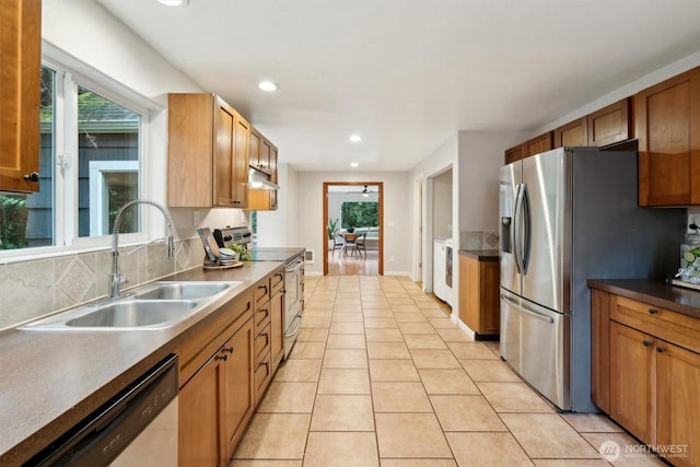 kitchen with light tile patterned floors, appliances with stainless steel finishes, under cabinet range hood, a sink, and recessed lighting