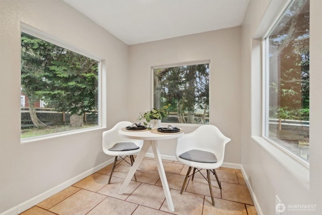 tiled dining room featuring baseboards