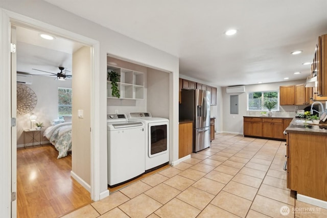 kitchen with an AC wall unit, brown cabinets, washer and dryer, and stainless steel fridge with ice dispenser