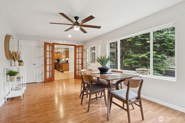 dining room with light wood finished floors, baseboards, and french doors