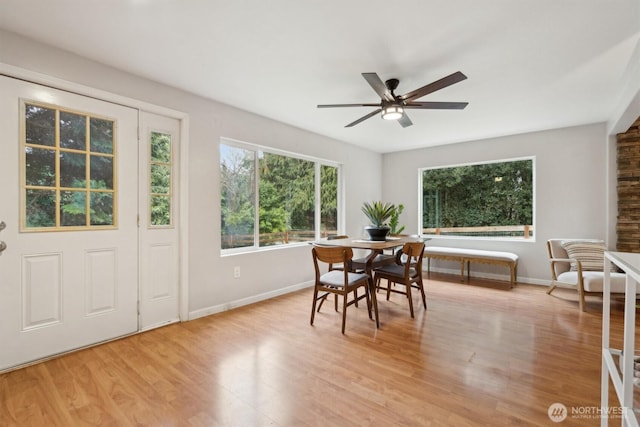 dining area with baseboards, ceiling fan, and light wood finished floors