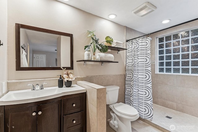 bathroom featuring visible vents, toilet, a tile shower, vanity, and recessed lighting