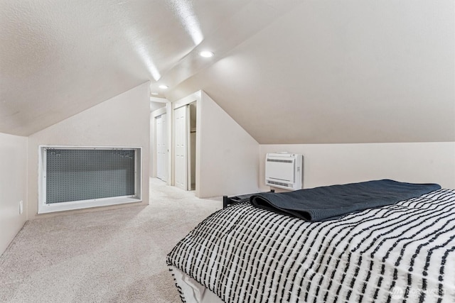 bedroom featuring lofted ceiling, a textured ceiling, recessed lighting, heating unit, and carpet