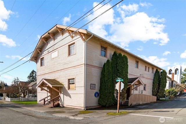 view of property exterior with entry steps and fence