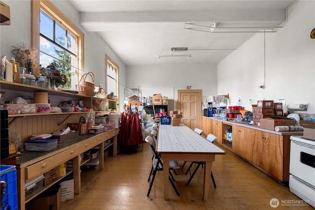 kitchen with light wood-style flooring, brown cabinetry, and white electric range