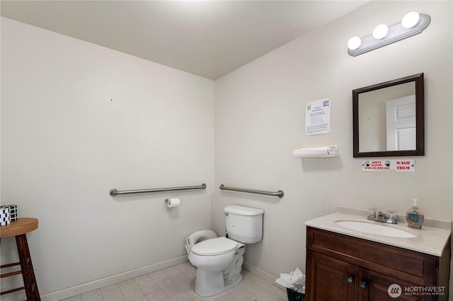 bathroom featuring toilet, baseboards, and vanity