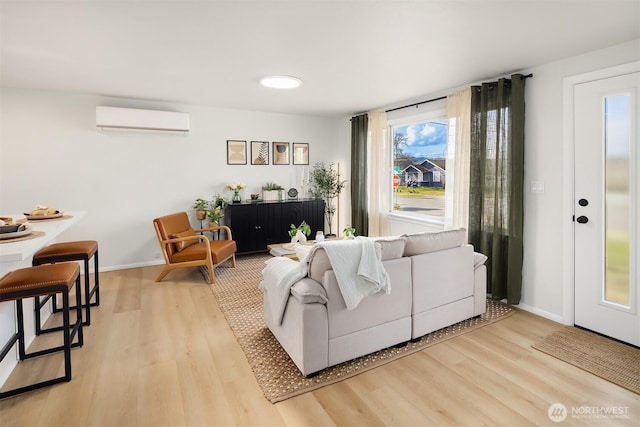 living room featuring a wall unit AC, wood finished floors, and baseboards