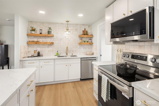 kitchen featuring appliances with stainless steel finishes, light wood-style floors, white cabinetry, open shelves, and a sink