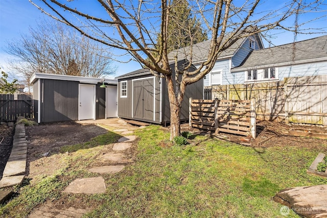 view of yard featuring an outbuilding, a storage unit, and fence