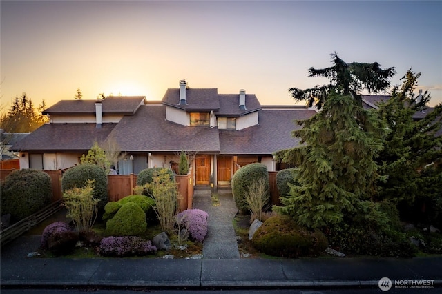 view of front of home with a chimney and fence