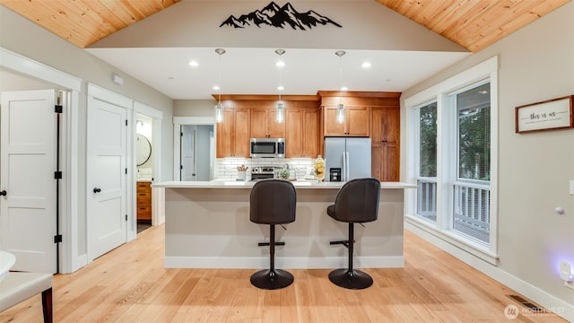 kitchen with visible vents, decorative backsplash, lofted ceiling, appliances with stainless steel finishes, and light countertops