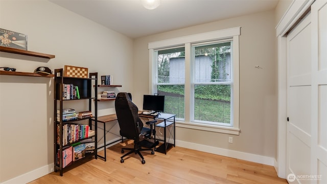 office with light wood-type flooring and baseboards