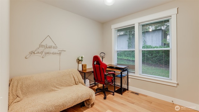 sitting room with baseboards, visible vents, and wood finished floors