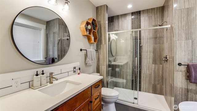 full bath with vanity, a shower stall, and toilet