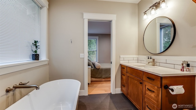 bathroom with a soaking tub, backsplash, vanity, and tile patterned floors