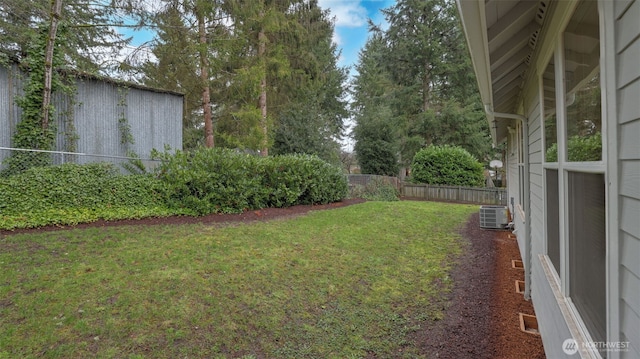 view of yard with central AC and a fenced backyard