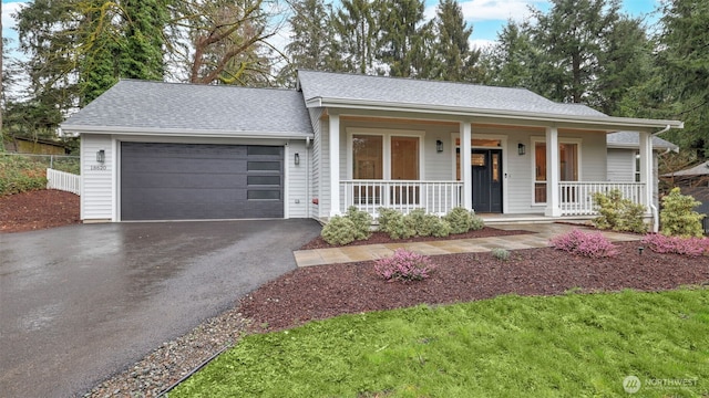 ranch-style house featuring a garage, aphalt driveway, a porch, and a shingled roof