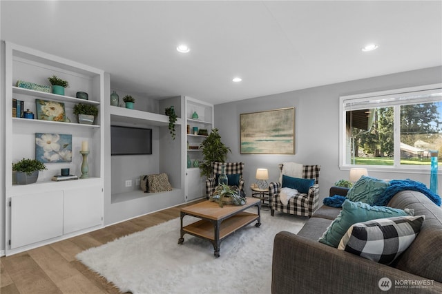 living area with light wood-type flooring and recessed lighting